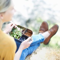 woman sitting in countryside eating healthy plastic free lunch. - junk food stock pictures, royalty-free photos & images