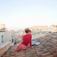 woman sitting on a tiled roof, reading cookbook - fashion stock pictures, royalty-free photos & images
