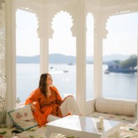 woman sitting on balcony during trip to udaipur - travel stockfoto's en -beelden