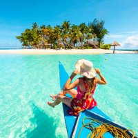 woman sitting on bangka boat approaching a tropical island - travel stock pictures, royalty-free photos & images