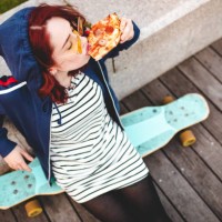woman sitting on long board and eating pizza - junk food stock pictures, royalty-free photos & images