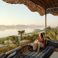 woman sitting on terrace and looking at nile at sunset in luxor - travel stock pictures, royalty-free photos & images