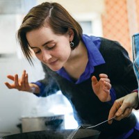 woman smelling food - food stockfoto's en -beelden