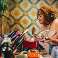 woman smelling food cooking in a pot on her kitchen stove - home decoration stock pictures, royalty-free photos & images