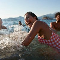 woman splashing and enjoying swim with friends - travel stock pictures, royalty-free photos & images