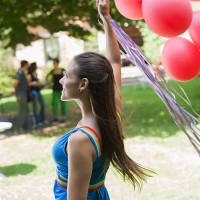 woman standing outdoors holding balloons and smiling - garden decoration stock pictures, royalty-free photos & images