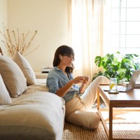 woman streaming something on a laptop in her living room - home decoration stock pictures, royalty-free photos & images