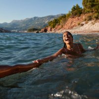 woman swimming with boyfriend in sea - travel stock pictures, royalty-free photos & images