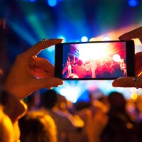 woman taking a photo with phone at music event - concert stock pictures, royalty-free photos & images