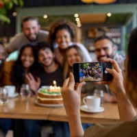 woman taking a picture of a group of people celebrating a birthday - home decoration stock pictures, royalty-free photos & images