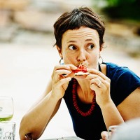 woman taking bite of pizza during backyard dinner - food stock pictures, royalty-free photos & images