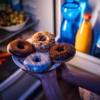 woman taking donuts out of the fridge - junk food stock pictures, royalty-free photos & images