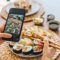 woman taking photo of maki sushi with smartphone - junk food stock pictures, royalty-free photos & images