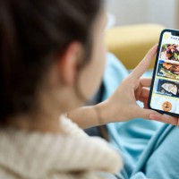 woman using a food delivery app on her mobile phone. - food stock pictures, royalty-free photos & images