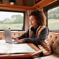 woman using laptop in camper van - travel stock-fotos und bilder