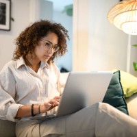 woman using laptop on sofa - home decoration photos et images de collection