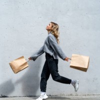 woman walking along street with two shopping bags - fashion stock pictures, royalty-free photos & images