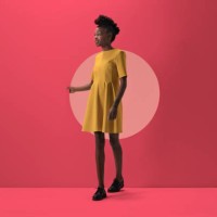 woman walking out from woman peeking out of round opening in coloured wall - fashion stock-fotos und bilder