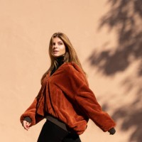 woman walking past a wall with shadow of a tree - fashion stock-fotos und bilder