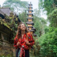 woman walking past the temple in the jungles in bali - travel stock-fotos und bilder
