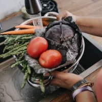woman washing fresh vegetable in sink at home - food stock-fotos und bilder