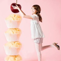 woman with cherry and cupcakes - junk food stockfoto's en -beelden