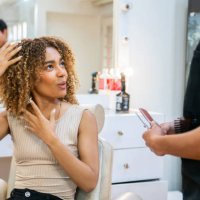 woman with curly hair telling her hairstylist how to cut her hair - hairstyle stock pictures, royalty-free photos & images