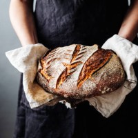 woman with fresh baked sourdough bread in kitchen - food stock pictures, royalty-free photos & images