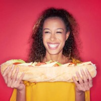 woman with giant sandwich - junk food stock-fotos und bilder