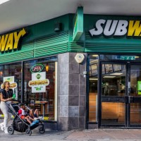 Woman with kids in a stroller walks past a Subway restaurant in London. Subway IP LLC, is an American multinational fast-food restaurant franchise...