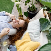 woman with neck pillow lying at backyard - garden decoration photos et images de collection