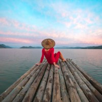 woman with red dress and traditional hat sitting on a wooden raft - travel stock pictures, royalty-free photos & images