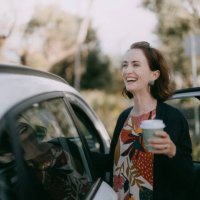woman with takeaway coffee getting in car - junk food stock pictures, royalty-free photos & images