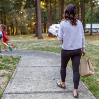 woman with two kids carrying takeout pizza into her home - junk food stock pictures, royalty-free photos & images