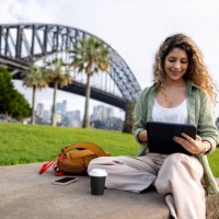 woman working outdoors on her tablet in sydney while drinking coffee - junk food stock pictures, royalty-free photos & images