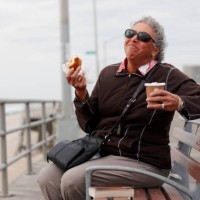 women eating pastry and drinking coffee on boardwalk - junk food stock pictures, royalty-free photos & images