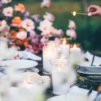 women ignite fire to decorative candles in stylish glass holders with thin wooden sticks at rustic table with elegant setting in garden closeup. - garden decoration stock pictures, royalty-free photos & images