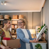 women unpacking and decorating new home together after moving in - home decoration stock pictures, royalty-free photos & images