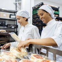 women working at an industrial bakery doing quality control on packages of bread - food stock pictures, royalty-free photos & images