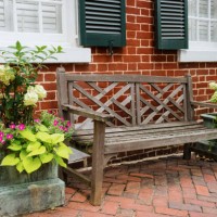 wood bench and potted plants outside of brick house - garden decoration stock pictures, royalty-free photos & images