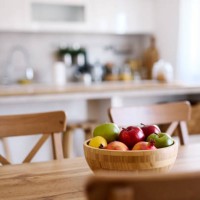 wooden bowl of fresh fruits is standing on a dining table in a modern kitchen - home decoration stock pictures, royalty-free photos & images