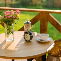 wooden table with a bouquet of flowers, an alarm clock and tea stands on a summer terrace. summer tea on terrace - garden decoration stock pictures, royalty-free photos & images