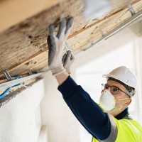 worker installing roof insulation in construction site with safety equipment - home decoration stock pictures, royalty-free photos & images