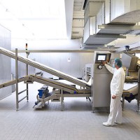 worker operating machine in an industrial bakery - food stock pictures, royalty-free photos & images