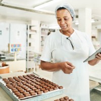 worker using a digital tablet in a commercial chocolate making factory - food stock pictures, royalty-free photos & images