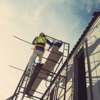 workers, contractors, engineers in plaid shirts and yellow hard hats carry toolboxes. inside the house that is being constructed, renovated, renovated by a professional technician who is ready to repair and improve and build 