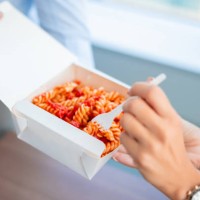 working and taking a bite from her colleague's take out lunch - junk food stock pictures, royalty-free photos & images