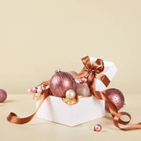 xmas still life composition with pastel pink christmas ornaments on solid beige background - home decoration stockfoto's en -beelden