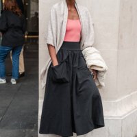 Yasmin Warsame wears pink top, beige scarf on the shoulders, black maxi skirt, black Gucci loafers, outside The Row, during the Womenswear...