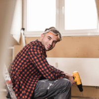 yooung man renovating his new home, holding electric drill - home decoration stock pictures, royalty-free photos & images